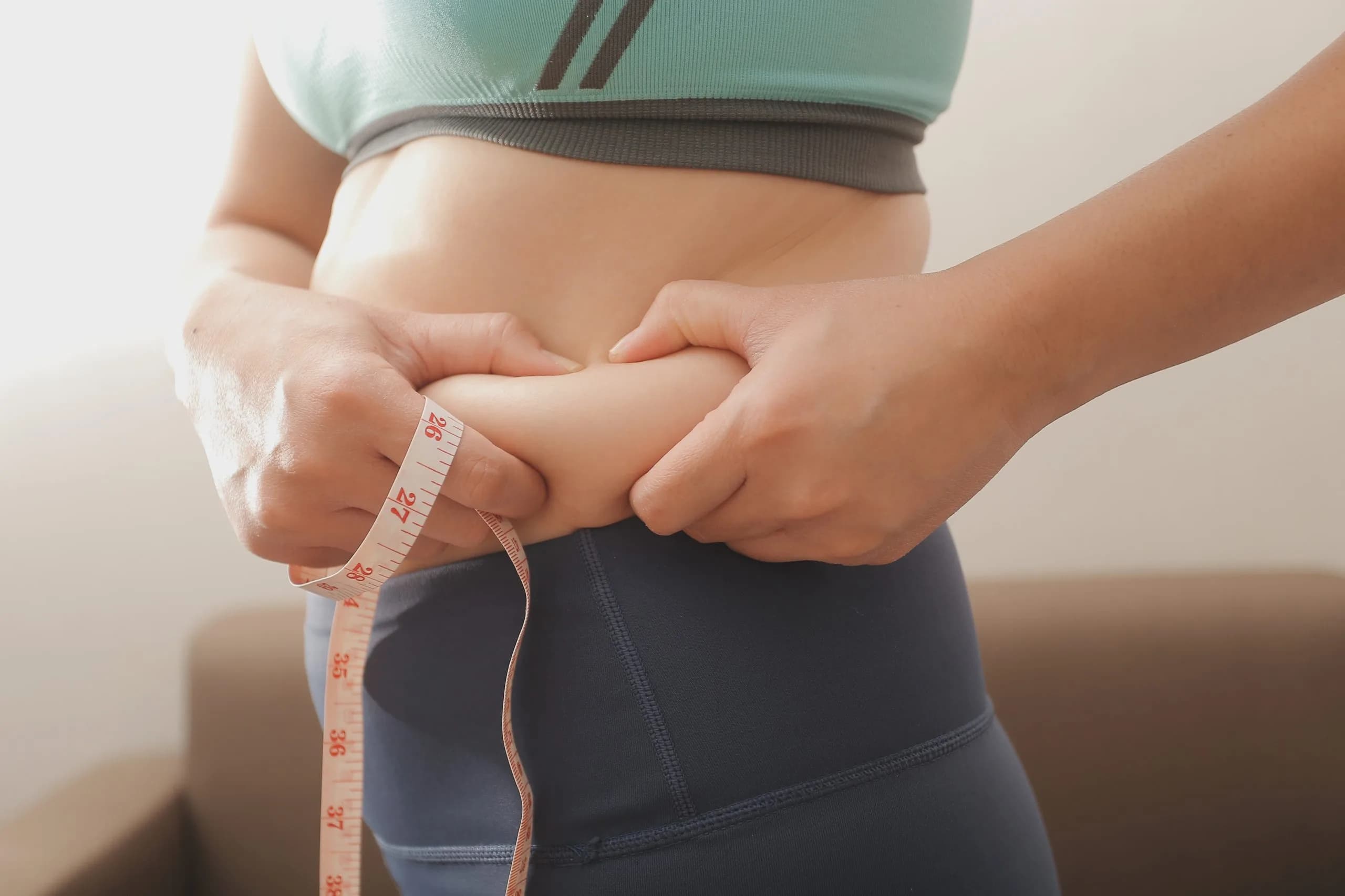 Women body fat belly. Obese woman hand holding excessive belly fat. diet lifestyle concept to reduce belly and shape up healthy stomach muscle.